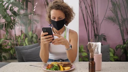 Woman With Mask Using Phone in Cafe