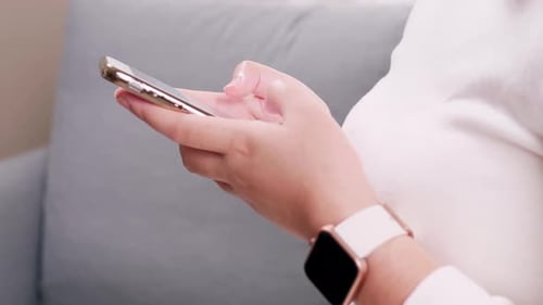 Close up of hand woman using smartphone and smartwatch in the living room for business and shopping