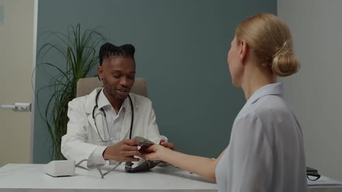 Doctor Checks Patient's Blood Pressure in Clinic