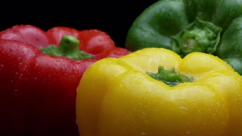 Fresh Raw Yellow, Red, Green, Peppers Rotating On A Black Plate