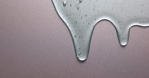 Silver Liquid Dripping Down on Shiny Surface