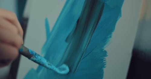 Mit dem Pinsel in der Hand Farbstriche auf Papier machen