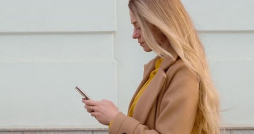 Woman with Smartphone Walking in the City