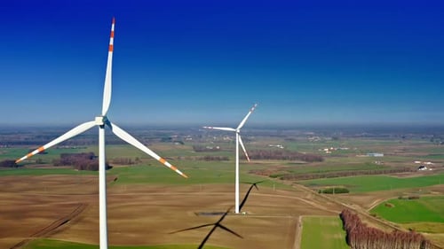 Wind turbines with blue sky on brown field, aerial view