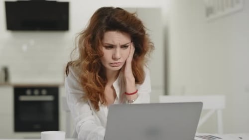 Frustrated Woman Working Computer at Home. Young Lady Staring Laptop at Kitchen.
