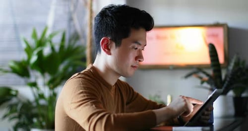 Young Adult Using Tablet Inside Modern Home