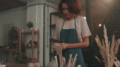 Young Woman Shaping Clay in Pottery Studio
