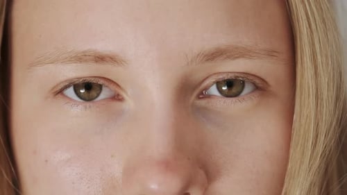 Eyes Looking in Camera Face Close Up Portrait of Young Woman with Blond Hair
