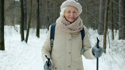 Dolly Shot of Beautiful Senior Sportswoman Enjoying Nordic Walking in Winter Park