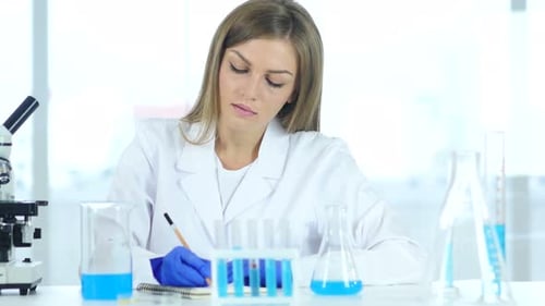 Female Scientist Examining Samples with Microscope and Notes
