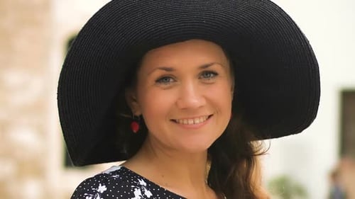Woman Smiling in Fashionable Hat and Polka Dot Dress