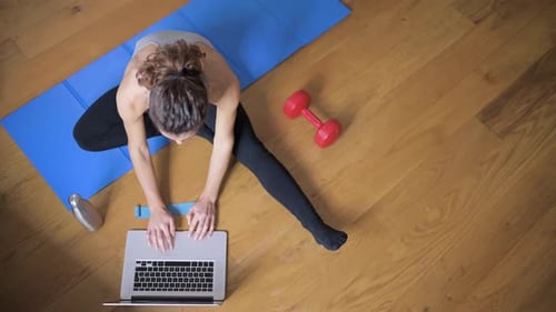 Woman Working Out While Using Laptop at Home