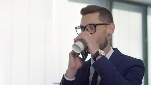 Busy Businessman Talking on Phone and Drinking Coffee
