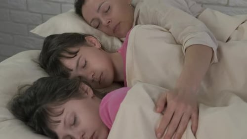 Woman and Children Sleeping Peacefully in Bed