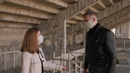 Couple portant des masques médicaux de protection se cognant les coudes au lieu de se serrer