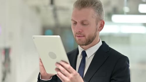 Professional Man Using Tablet in Modern Office