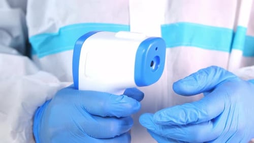 Hand Holding Infrared Thermometer To Measuring Temperature.