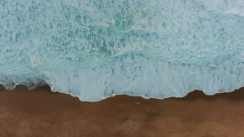 Amazing Waves with White Foam Roll on Clean Sand Upper View