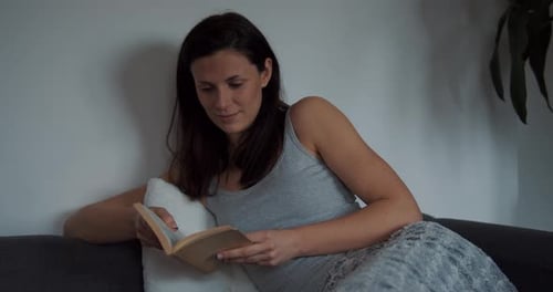 Woman Reading a Book on the Couch Indoors