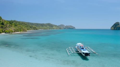 Aerial Circle Drone Footage of a Huge Island Hopping Boat Moored in Shallow Water in Cadlao Lagoon