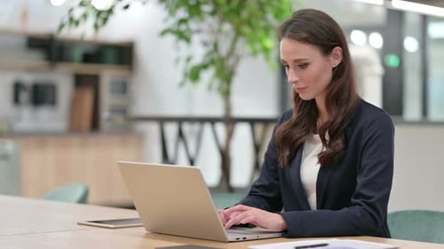Woman Typing then Massaging Wrist in Office