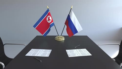 Flags of North Korea and Russia and Papers on the Table
