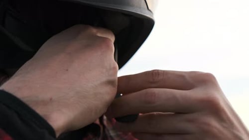 Close Up Footage Male Biker Hands in Red Shirt Button Up Motorcycle Black Helmet. Concept of Safety