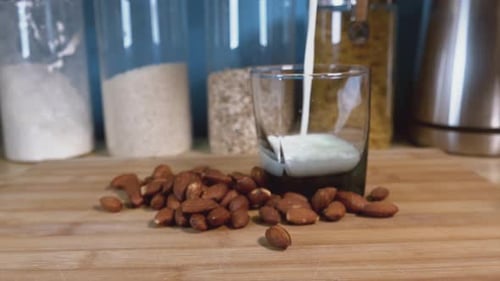 Almond Milk Poured Into Glass with Almonds
