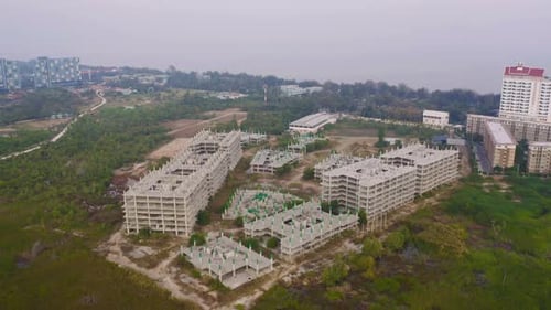 Aerial top view of abandoned apartment or hotel under construction site with structure.