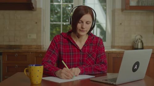 Woman Learning Online Using Laptop At Home