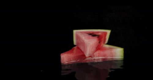 Watermelon Wedges on Black Reflective Surface