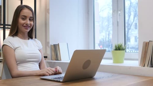 Young Woman Typing on Laptop in Home Office