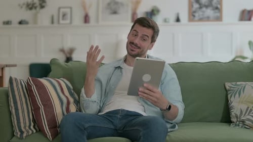 Man on Couch Video Calling with Tablet