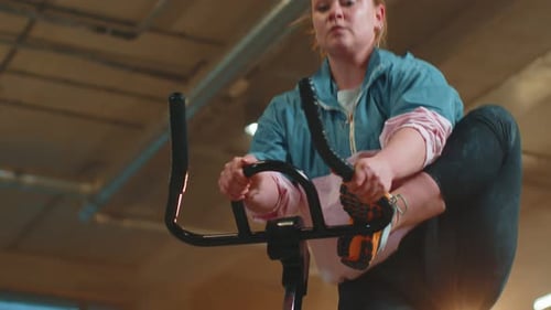 Healthy Caucasian Woman Exercising Workout on Stationary Cycling Machine Bike in Gym Slow Motion