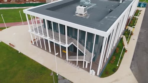 Office Building with Flat Roof and White Poles Near Lawn