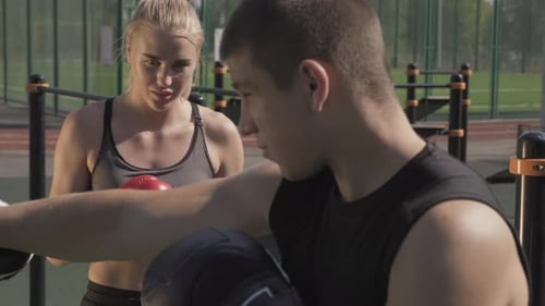 Woman Boxing and Training with Coach Outdoors
