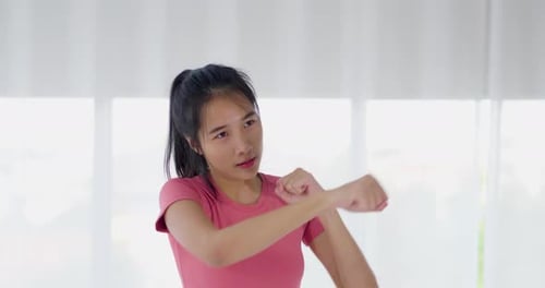 Young Adult Woman Throwing Punches Indoors