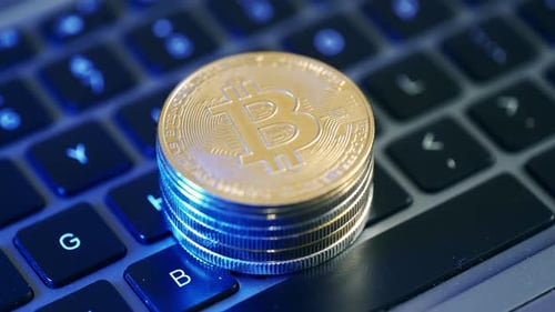 Stack of Bitcoin Coins on Laptop Keyboard