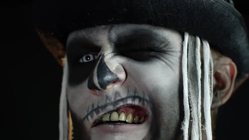 Close Up Footage of Sinister Man with Halloween Skeleton Makeup Making Faces, Trying To Scare