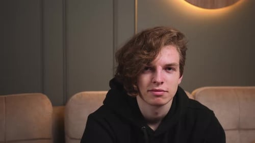 Young Man with Curly Hair Wearing Hoodie
