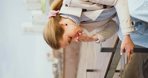 Blonde Woman Sits On Bench Holding Phone
