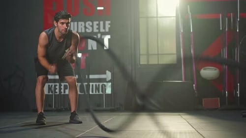 Muscular Man Working Out With Ropes at the Gym