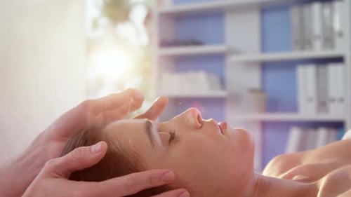 Patiente recevant un massage de la tête par un physiothérapeute
