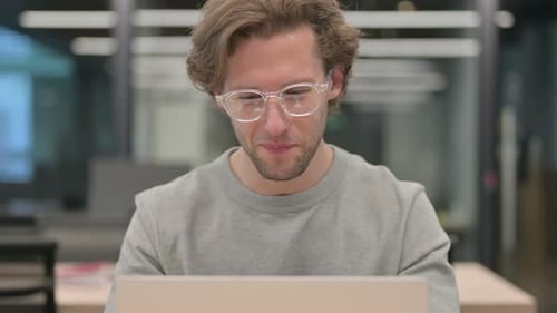 Young Man Working on Laptop During Video Call