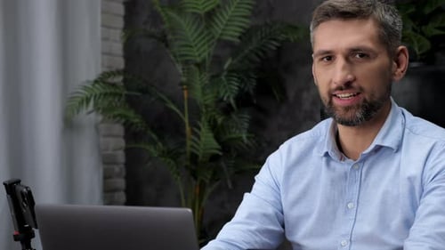 Close Up Man Stock Trader Broker Work for Laptop Turns Head to Camera with Smile