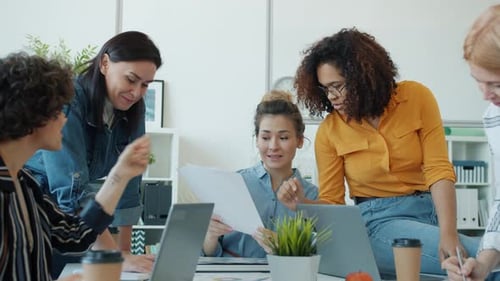 Slow Motion of Smart Female Office Workers Talking and Working with Laptop Sharing Ideas at Work