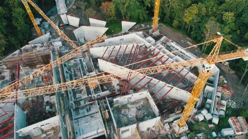 Aerial View Construction of a New Building with High Tower Cranes in Green Area