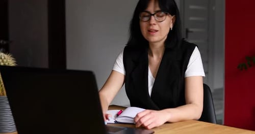 Real estate agent woman in her workplace with laptop, giving keys to customer