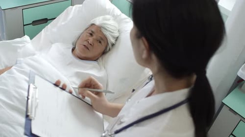 Patient Talks to Doctor in Hospital Bed