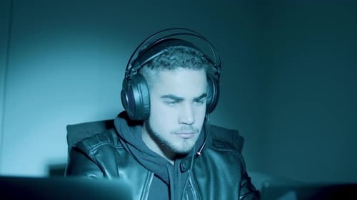 Man with Headphones in Dark Room